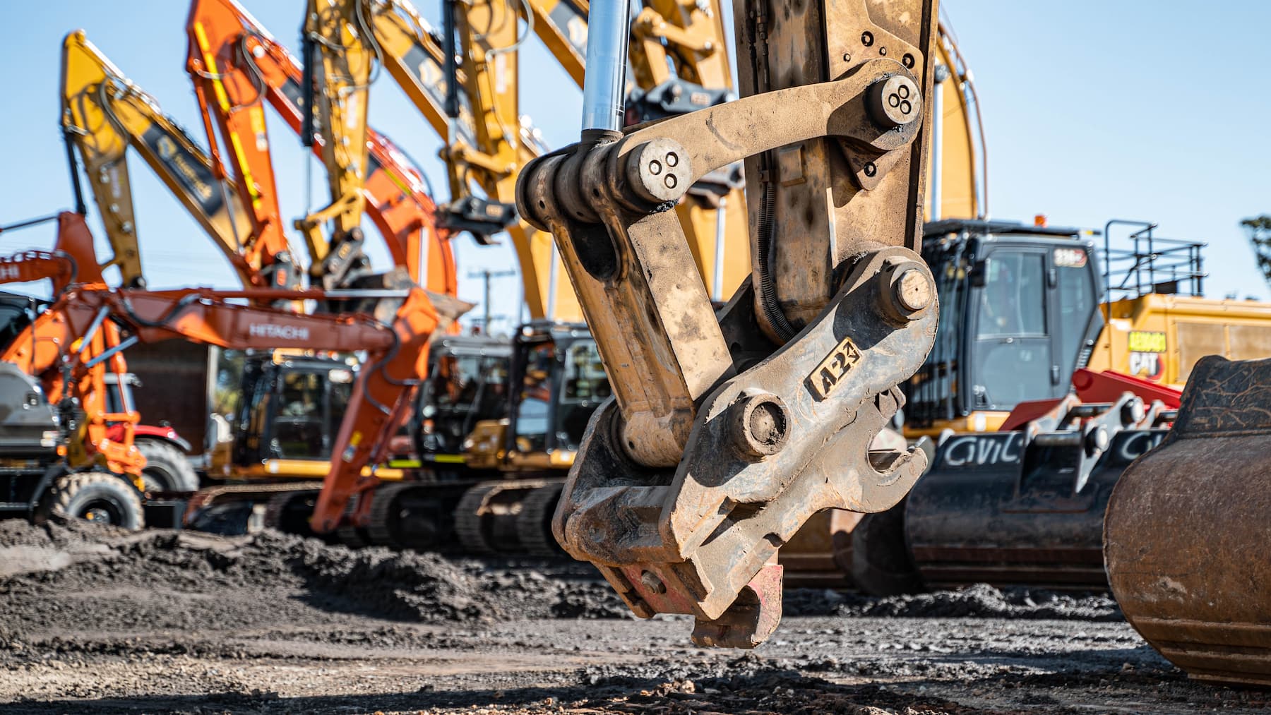 multiple excavators lined up each fitted with a sure-grip quick hitch