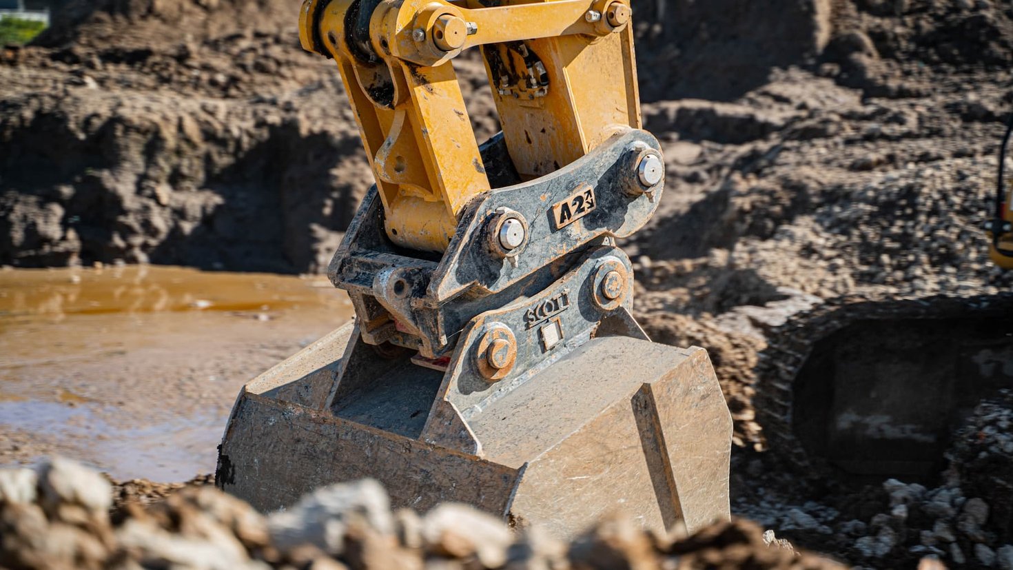Excavators digging through mud using an Attach2 Sure-Grip hitch with GP bucket